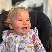 Lyana participe au concours pour gagner de l'argent avec cette photo : baby, child, smiling, blonde_hair, blue_eyes, onesie, animal_print, cute, toddler, happy, portrait, indoor, cushion, chair, soft_light, close_up, infant, clothing, sitting, face