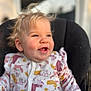baby, child, smiling, blonde_hair, blue_eyes, onesie, animal_print, cute, toddler, happy, portrait, indoor, cushion, chair, soft_light, close_up, infant, clothing, sitting, face