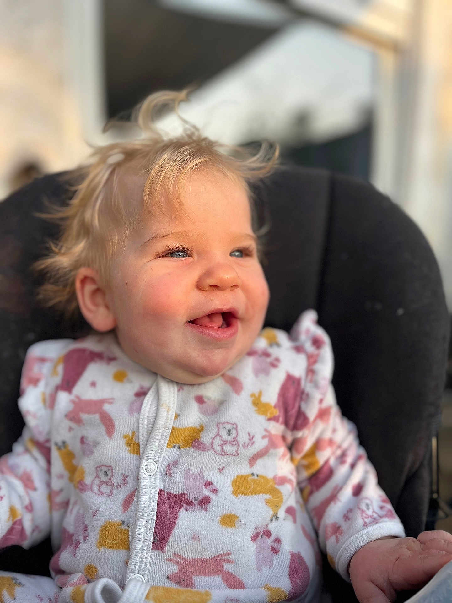 Lyana participe au concours pour gagner de l'argent avec cette photo : baby, child, smiling, blonde_hair, blue_eyes, onesie, animal_print, cute, toddler, happy, portrait, indoor, cushion, chair, soft_light, close_up, infant, clothing, sitting, face
