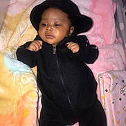 Jocelyn is registered to the contest to win money with this photo: baby, infant, black_clothing, hoodie, blanket, pastel_colors, soft_texture, fist, earring, lying_down, indoor, cute, child, young, portrait, comfortable, warm, sleeping_area, baby_bed, face