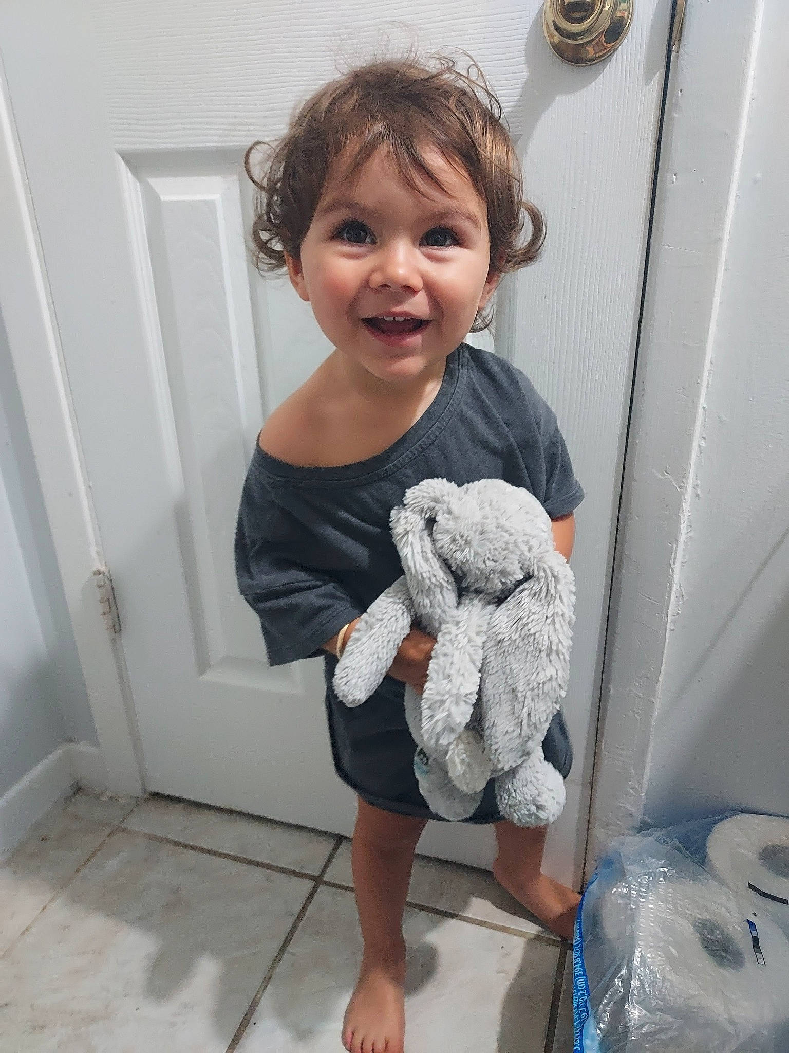 Korra is registered to the contest to win money with this photo: arm, baby_toddler_clothing, child, door, finger, hand, human_body, human_leg, joint, joy, knee, pattern, person, room, sleeve, smile, stuffed_toy, t_shirt, thigh, thumb