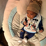 Ouetin joined the competition — help win amazing prizes! baby, infant, child, portrait, sitting, rocker, baby_seat, blanket, bib, pacifier, knit_hat, clothing, mickey_mouse, cartoon, indoor, cozy, sleepy, face, hands, feet