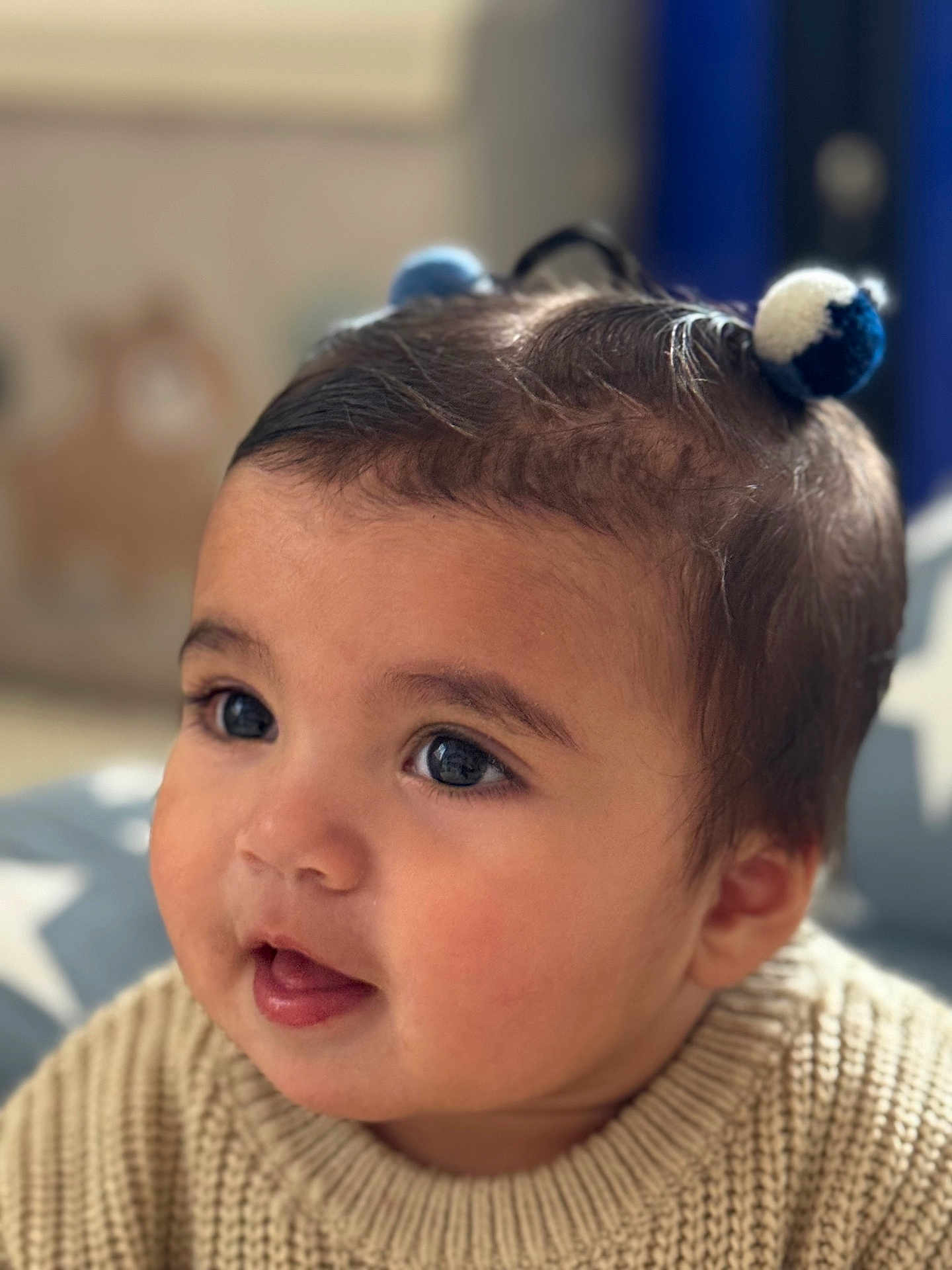 Vivienne joined the competition — help win amazing prizes! baby, child, portrait, closeup, face, eyes, hair_buns, knitted_sweater, cozy, indoor, soft_light, cute, young_child, skin, expression, head, person, smiling, background_blur, star_pattern