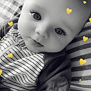 Karsyn is registered to the contest to win money with this photo: baby, infant, child, portrait, close_up, wide_eyed, lying_down, striped_clothing, onesie, blanket, cushion, bed, indoor, black_and_white, yellow_hearts, heart_stickers, face, eyes, cute, photography