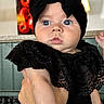 Luna Ray is registered to the contest to win money with this photo: adult_arm, baby, black_clothing, black_headband, blue_eyes, bow, child, close_up, colorful_background, face, fashion_portrait, held_baby, indoor, infant, kitchen, lace_outfit, neutral_expression, photography, portrait, wide_eyed