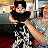 Luna Ray joined the competition — help win amazing prizes! adult, baby, black_and_white, bow, ceiling_fan, child, cow_print, dress, family, headband, held, indoor, infant, portrait, restaurant, sitting, smiling, table, woman, wooden_floor