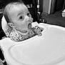 Sakari joined the competition — help win amazing prizes! baby, high_chair, popsicle, indoor, monochrome, child, tongue, curious, face, feeding, seat, furniture, table, clothing, person, infant, expression, hand, young_child, cute