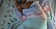 Sierra is registered to the contest to win money with this photo: baby, blanket, sleeping, crib, patterned_sheet, footprints, pacifier, infant, soft, cozy, pastel_colors, child, resting, cute, indoors, fabric, wrapped, newborn, peaceful, toddler