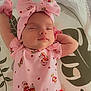 baby, infant, sleeping, pink_clothing, headband, bow, arms_up, blanket, pattern, cute, peaceful, resting, child, portrait, indoors, soft_lighting, toddler, young_child, sleep, cozy