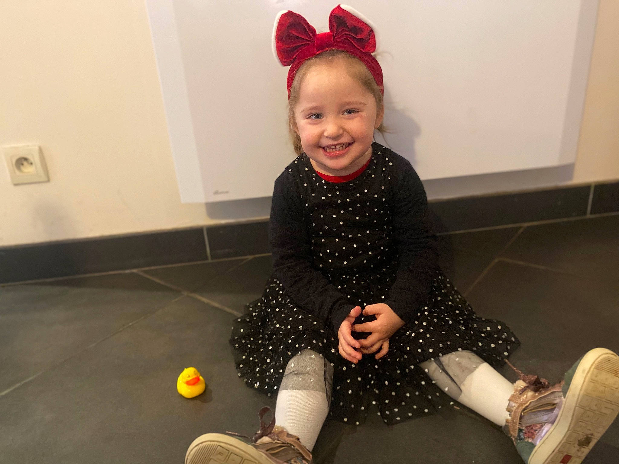 Marie-lou a rejoint le concours — aidez-le/la à gagner de superbes lots ! baby, baby_toddler_clothing, child, costume_hat, dress, floor, flooring, fun, happy, human_leg, joy, knee, leggings, pattern, person, room, sitting, sleeve, smile, sock