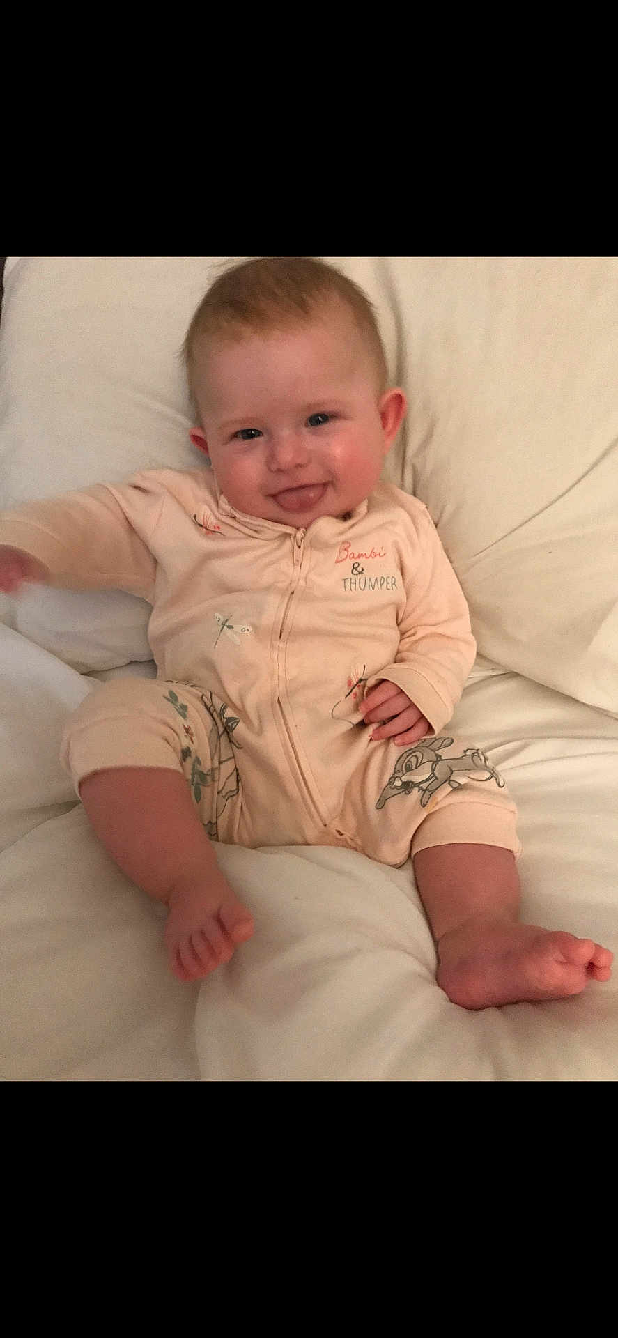 Nevaeh-Rae is registered to the contest to win money with this photo: baby, child, infant, onesie, smile, tongue_out, cute, sitting, soft_surface, white_background, clothing, foot, hand, face, happy, indoors, portrait, young_child, expression, cozy