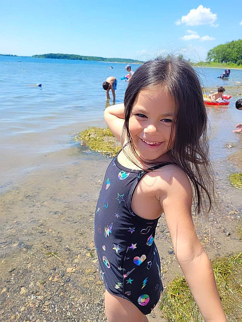 Katalya is registered to the contest to win money with this photo: azure, beach, black_hair, fun, happy, joy, lake, leisure, natural_environment, one_piece_swimsuit, people_in_nature, people_on_beach, person, sand, sky, smile, summer, swimwear, thigh, travel