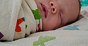 Jesse is registered to the contest to win money with this photo: newborn, baby, sleeping, hospital, crib, blanket, swaddled, infant, bed, face, peaceful, child, medical, healthcare, resting, indoors, colorful, soft, quiet, calm