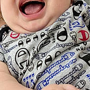 Jesse is registered to the contest to win money with this photo: baby, infant, smiling, laughing, face, hand, onesie, clothing, pattern, chubby_cheeks, close_up, happy, cute, child, person, indoor, furniture, couch, portrait, skin
