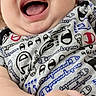baby, infant, smiling, laughing, face, hand, onesie, clothing, pattern, chubby_cheeks, close_up, happy, cute, child, person, indoor, furniture, couch, portrait, skin