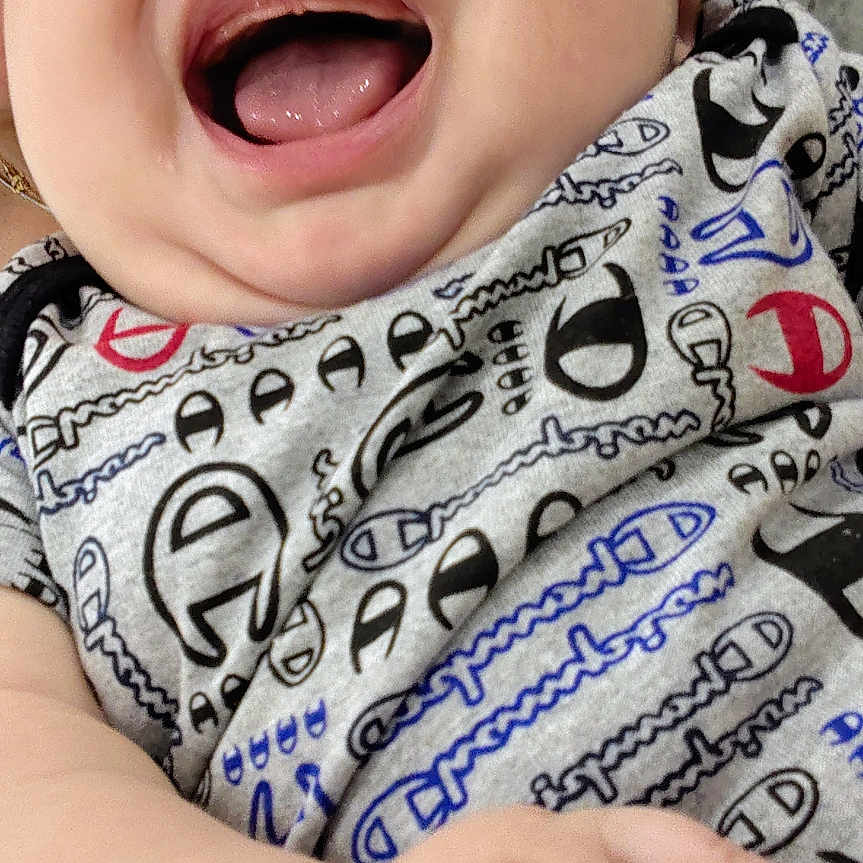 Jesse is registered to the contest to win money with this photo: baby, child, chubby_cheeks, close_up, clothing, couch, cute, face, furniture, hand, happy, indoor, infant, laughing, onesie, pattern, person, portrait, skin, smiling