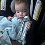 baby, sleeping, car_seat, bottle, blanket, child, infant, face, hand, safety_belt, close_up, indoors, soft_lighting, peaceful, cute, resting, cozy, blue_blanket, animal_print, water_bottle
