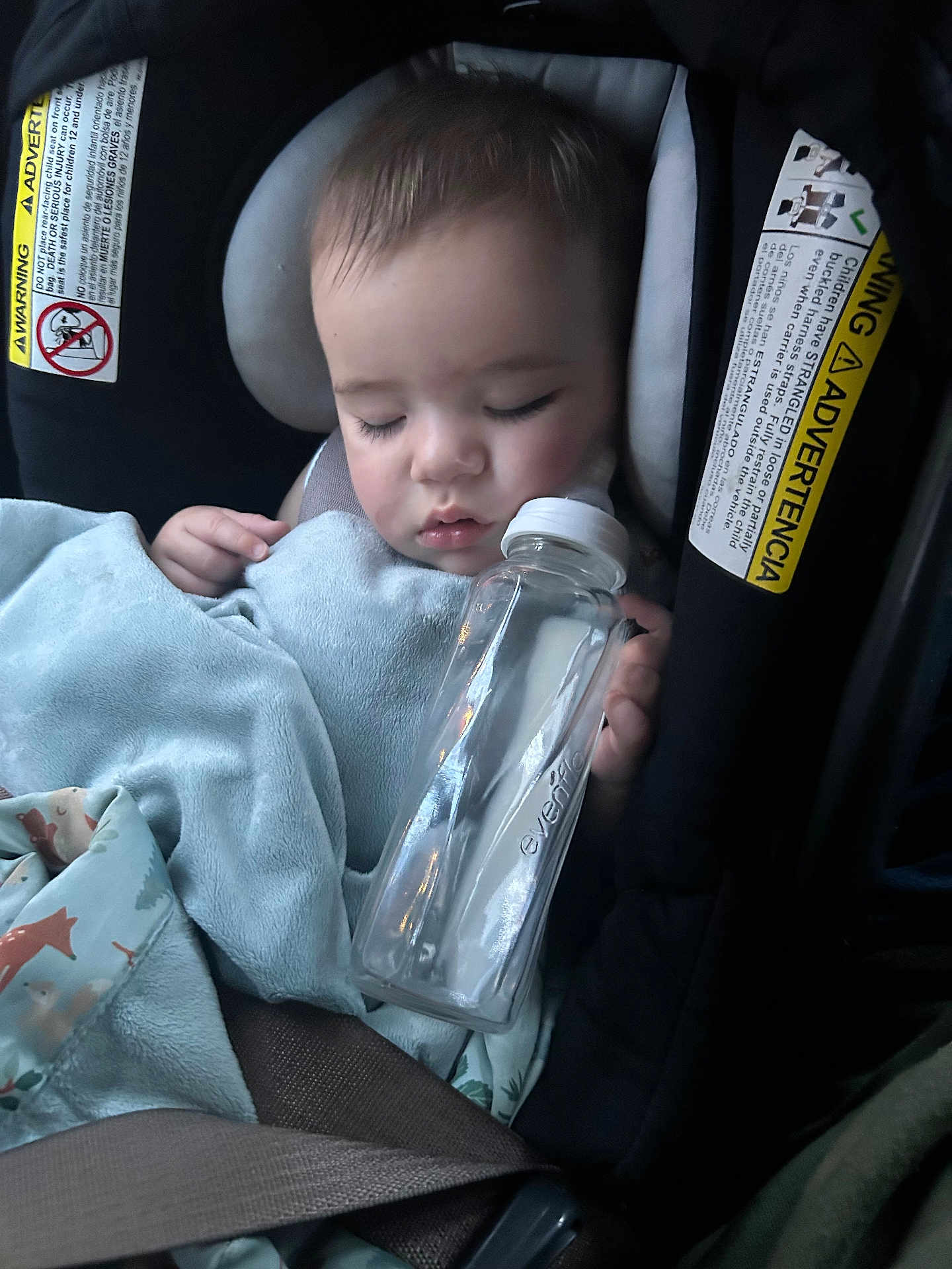 Oliver joined the competition — help win amazing prizes! baby, sleeping, car_seat, bottle, blanket, child, infant, face, hand, safety_belt, close_up, indoors, soft_lighting, peaceful, cute, resting, cozy, blue_blanket, animal_print, water_bottle