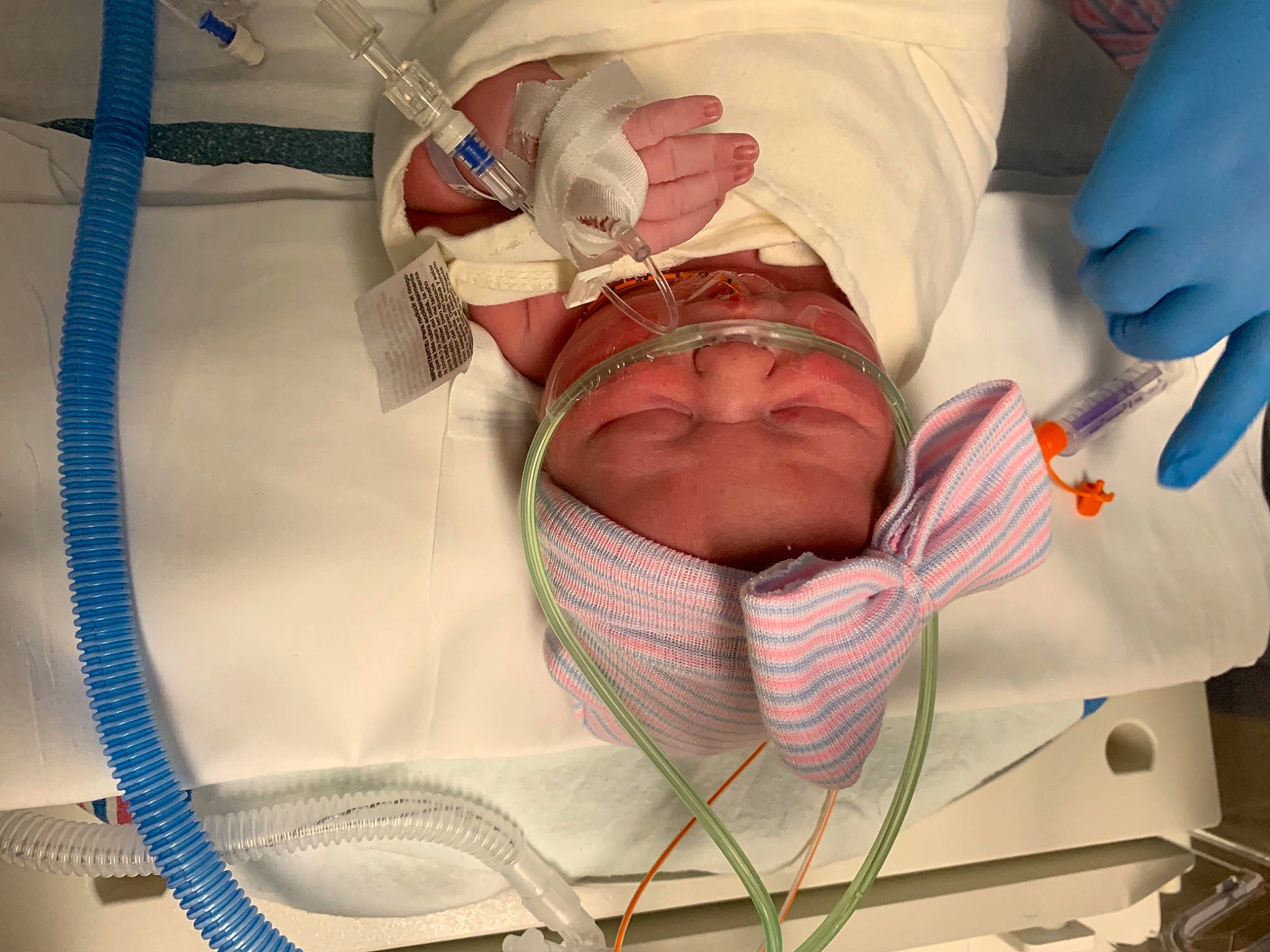 Paislynn is registered to the contest to win money with this photo: baby, baby_sleeping, child, comfort, headwear, health_care, hospital, hospital_bed, hospital_gown, linens, medical, medical_equipment, medical_procedure, mouth, patient, person, room, service, skin, textile