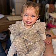 Kiara a rejoint le concours — aidez-le/la à gagner de superbes lots ! toddler, child, smiling, blue_eyes, dress, tights, sitting, indoor, person, happy, face, hair, legs, hands, lap, blurred_background, cozy, cute, portrait, young_child