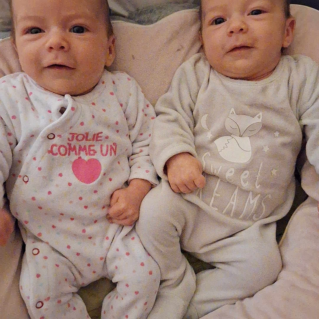Anna Et Ynaïa participe au concours pour gagner de l'argent avec cette photo : baby, bed, blanket, child, comfort, cozy, cushion, cute, face, holding_hands, indoors, infant, lying_down, newborn, pajamas, portrait, sleepwear, smiling, soft_lighting, twin