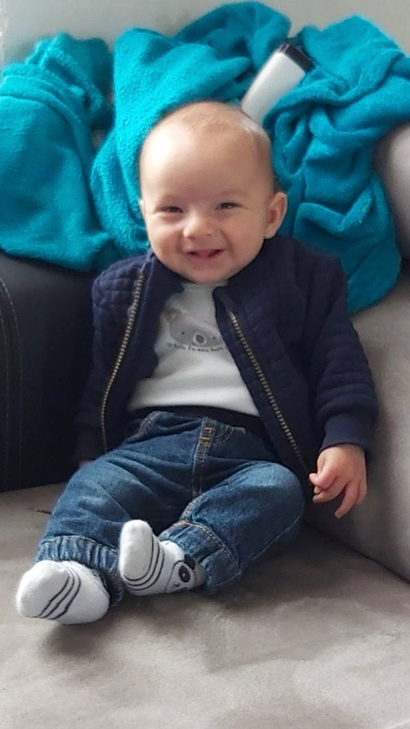 Eren participe au concours pour gagner de l'argent avec cette photo : baby, blue, cheek, child, jeans, joy, person, sitting, smile, toddler