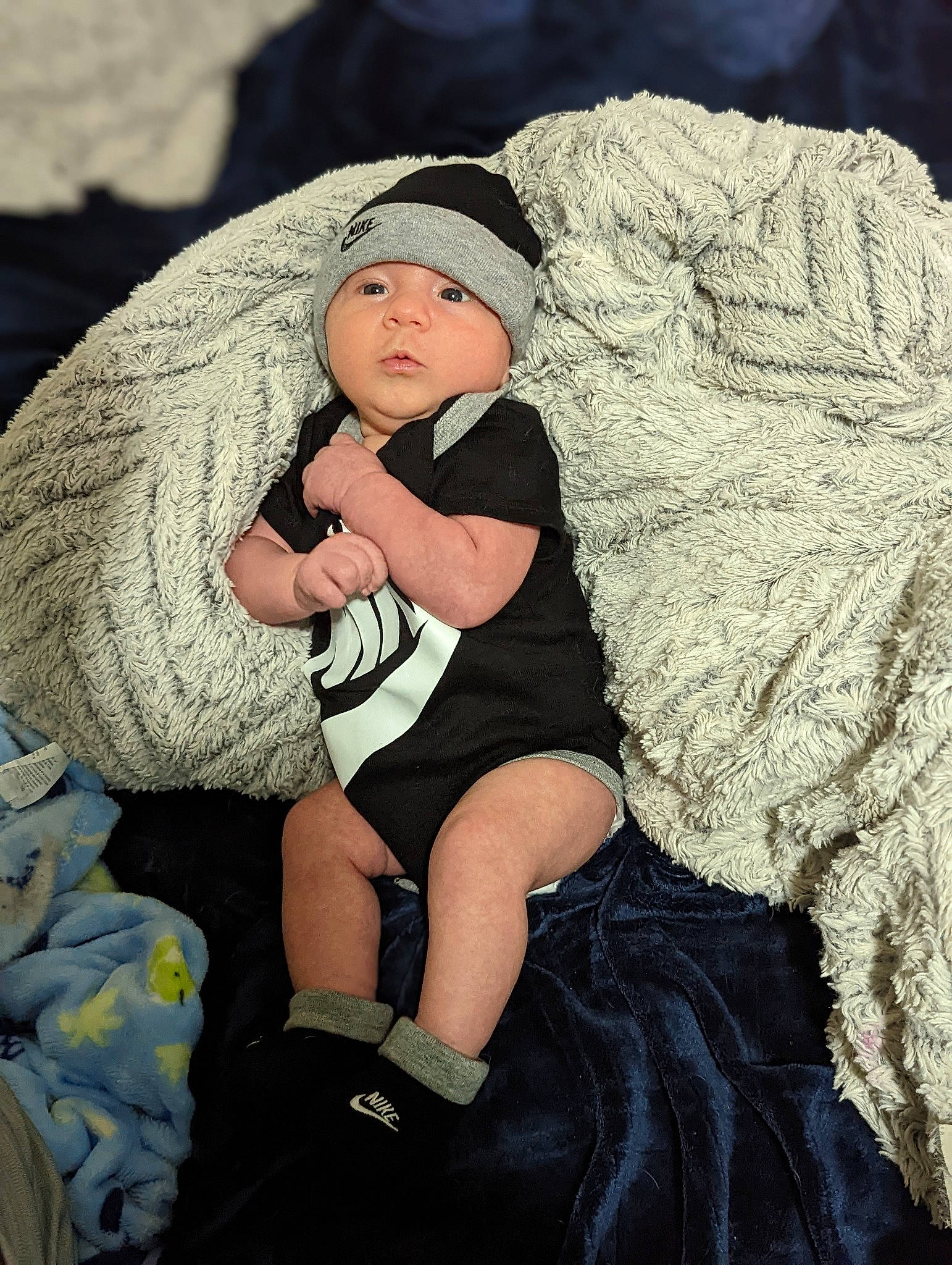 Desmond is registered to the contest to win money with this photo: baby, baby_toddler_clothing, beanie, cap, child, comfort, eye, fashion_accessory, flash_photography, fun, grass, happy, headwear, human_body, human_leg, linens, person, rock, sitting, sun_hat
