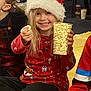 Daisy joined the competition — help win amazing prizes! child, santa_hat, popcorn, holiday, festive_sweater, smile, indoor, people, reindeer_antlers, sitting, yellow_blanket, party, happy, casual_clothing, long_hair, toy, legs, seated, group, celebration
