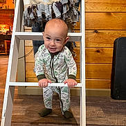Kyllian joined the competition — help win amazing prizes! baby, blanket, child, cozy, cute, fabric, feet, floor, hands, home_interior, indoor, ladder, onesie, person, playful, smiling, standing, warm_lighting, wood_floor, wooden_wall