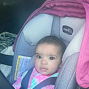 Aubrey is registered to the contest to win money with this photo: baby, car_seat, child, seat_belt, infant, car_interior, pink, gray, clothing, person, face, sitting, young_child, portrait, seat, straps, looking, indoors, eyes, head
