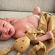 Malone a rejoint le concours — aidez-le/la à gagner de superbes lots ! baby, newborn, infant, smiling, plush_toy, bunny, couch, fabric, texture, child, happy, cute, skin, hand, lying_down, indoors, soft_toy, comfort, relaxed, small