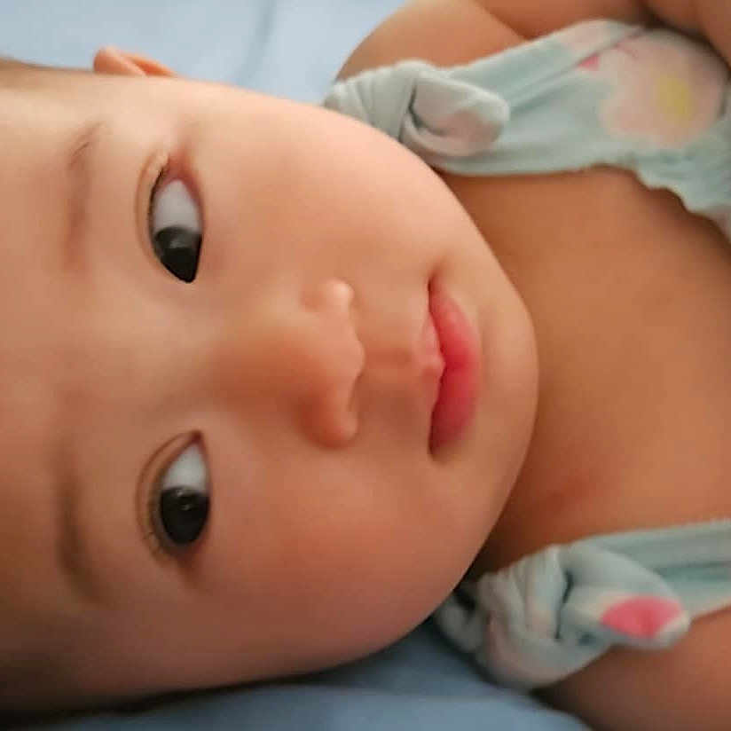 Celine joined the competition — help win amazing prizes! baby, bed, blue_background, child, close_up, clothing, cute, expression, eyes, face, infant, lying_down, mitten, newborn, person, portrait, resting, skin, sleepwear, soft_lighting