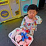 arcade, arcade_machine, child, claw_machine, colorful, dress, entertainment, family_friendly, floor, girl, indoors, patterned_clothing, photography, plush_toys, portrait, shopping, standing, thoughtful, toddler, toy_basket