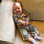 baby, cartoon_print, casual, child, clothing, comfortable, couch, cozy, cute, furniture, happy, home, indoor, infant, person, portrait, relaxing, smiling, socks, young