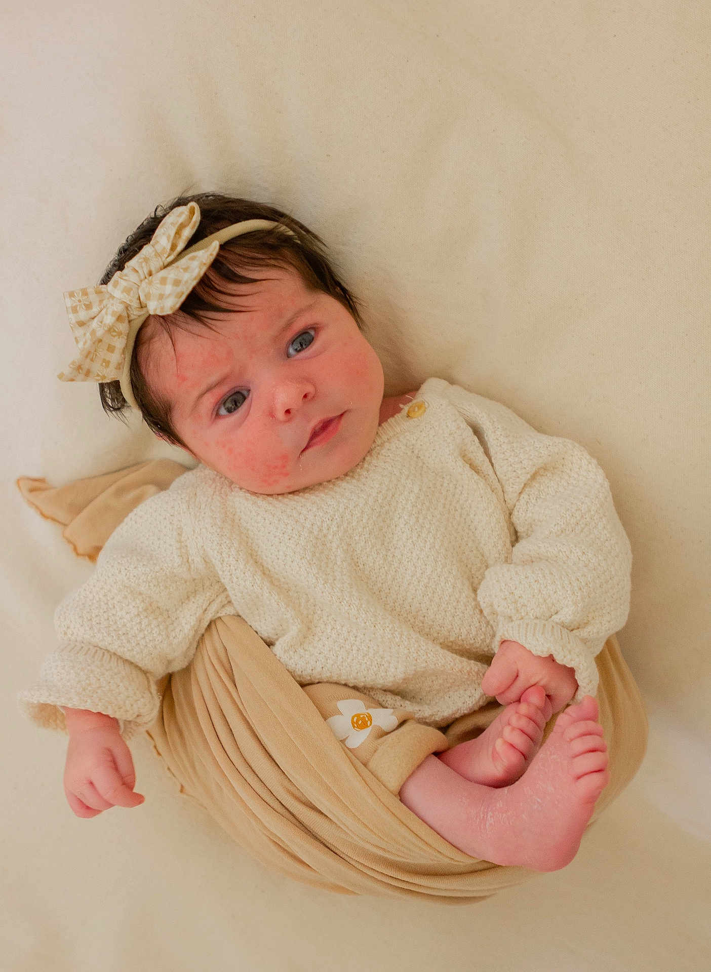 Line participe au concours pour gagner de l'argent avec cette photo : baby, newborn, infant, headband, bow, knitted_sweater, beige, blanket, swaddle, toes, feet, pink_cheeks, curious_expression, lying_down, soft_texture, closeup, portrait, hair, skin, cozy