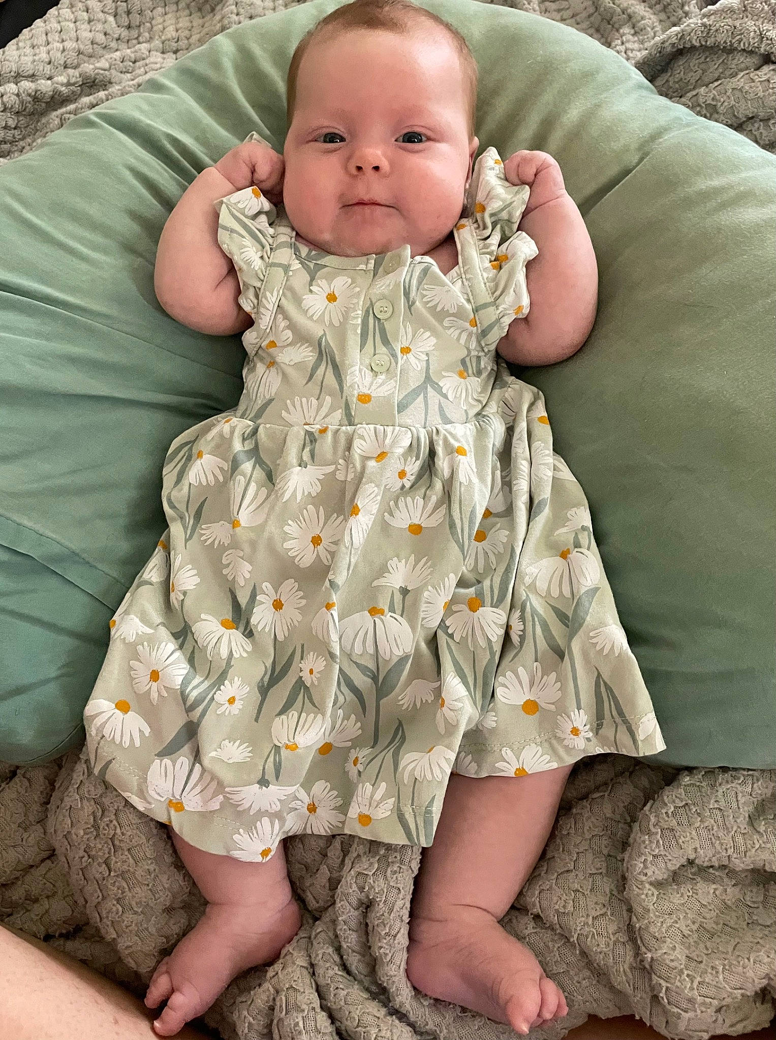 Stevie is registered to the contest to win money with this photo: baby, baby_toddler_clothing, cheek, child, comfort, eye, grass, green, head, human_leg, iris, leg, linens, pattern, person, sitting, skin, sleeve, textile, thigh