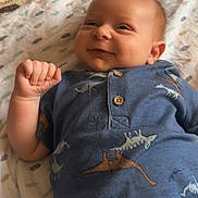 Jaxon joined the competition — help win amazing prizes! baby, infant, smile, blue_shirt, dinosaur_print, blanket, lying_down, cute, child, young, portrait, happy, indoors, soft_light, cozy, small_hand, skin, face, eyes, buttoned_shirt