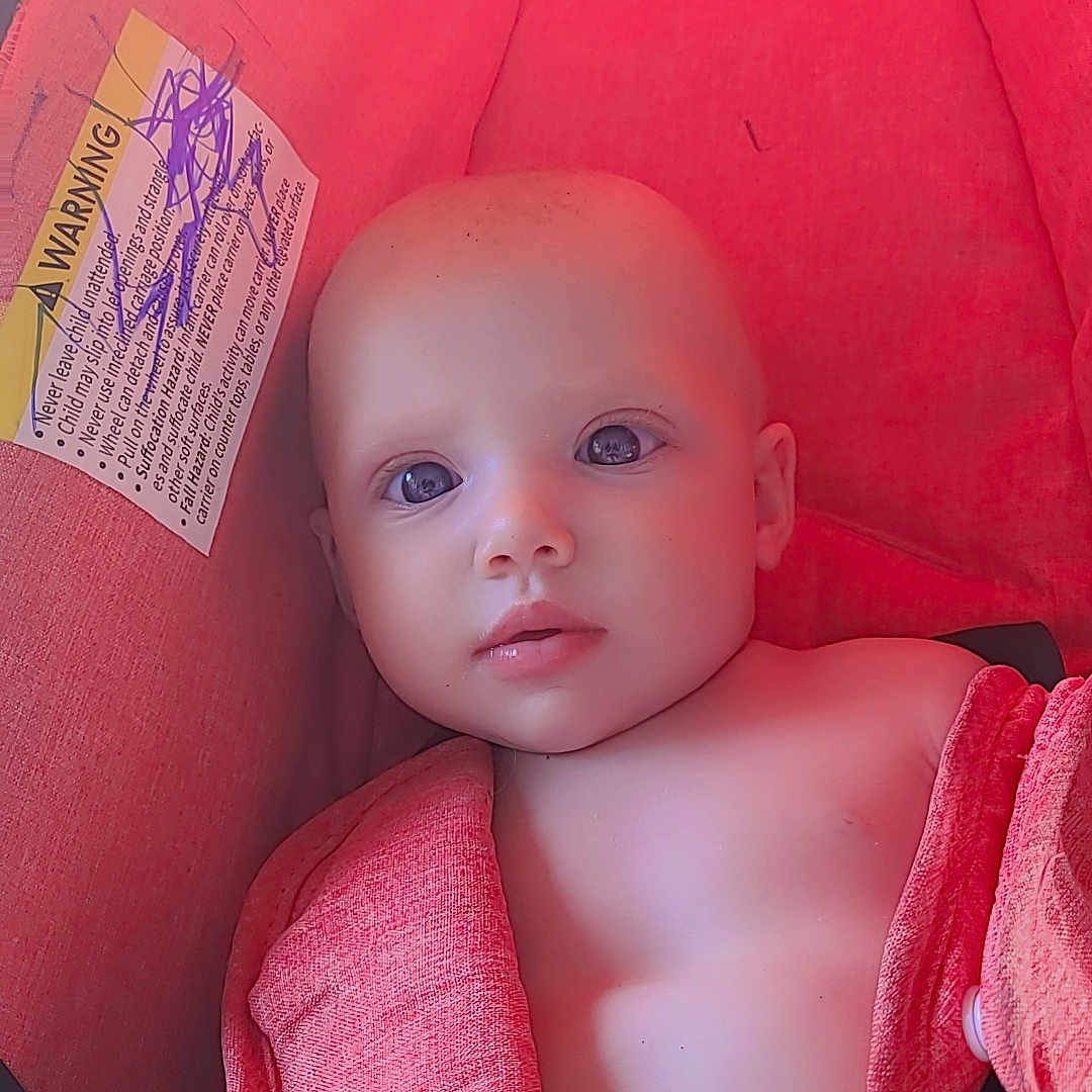 Cali joined the competition — help win amazing prizes! baby, child, infant, car_seat, red, towel, straps, face, skin, eyes, head, seat, indoor, closeup, portrait, young, child_seat, safety, candid, baby_boy