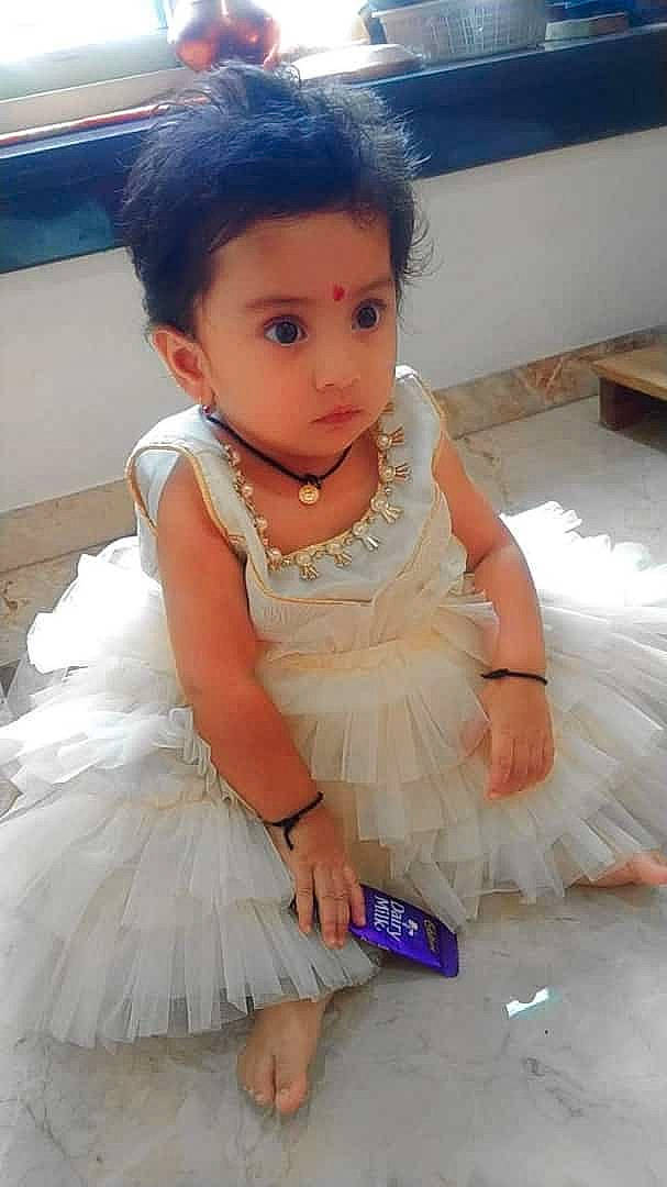 Vedanti is registered to the contest to win money with this photo: baby, baby_toddler_clothing, blue, bridal_accessory, clothing, day_dress, dress, embellishment, face, fashion_design, flash_photography, formal_wear, happy, headpiece, iris, jewellery, necklace, person, pink, ruffle