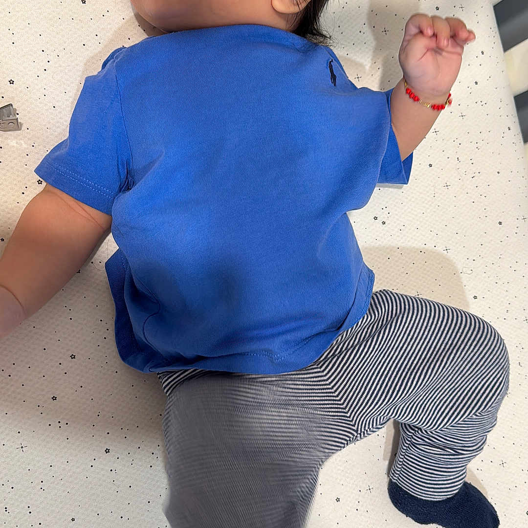 Leo Cuji joined the competition — help win amazing prizes! baby, blue_shirt, bracelet, child, clothing, crib, curious, cute, footwear, indoors, infant, lying_down, mattress, motion_blur, person, portrait, sock, stars_pattern, striped_pants, young_child