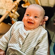 Rafaël participe au concours pour gagner de l'argent avec cette photo : baby, infant, smile, happy, face, person, hand, clothing, striped, onesie, cute, portrait, indoor, soft_lighting, blurred_background, child, newborn, warm_tone, cozy, expression