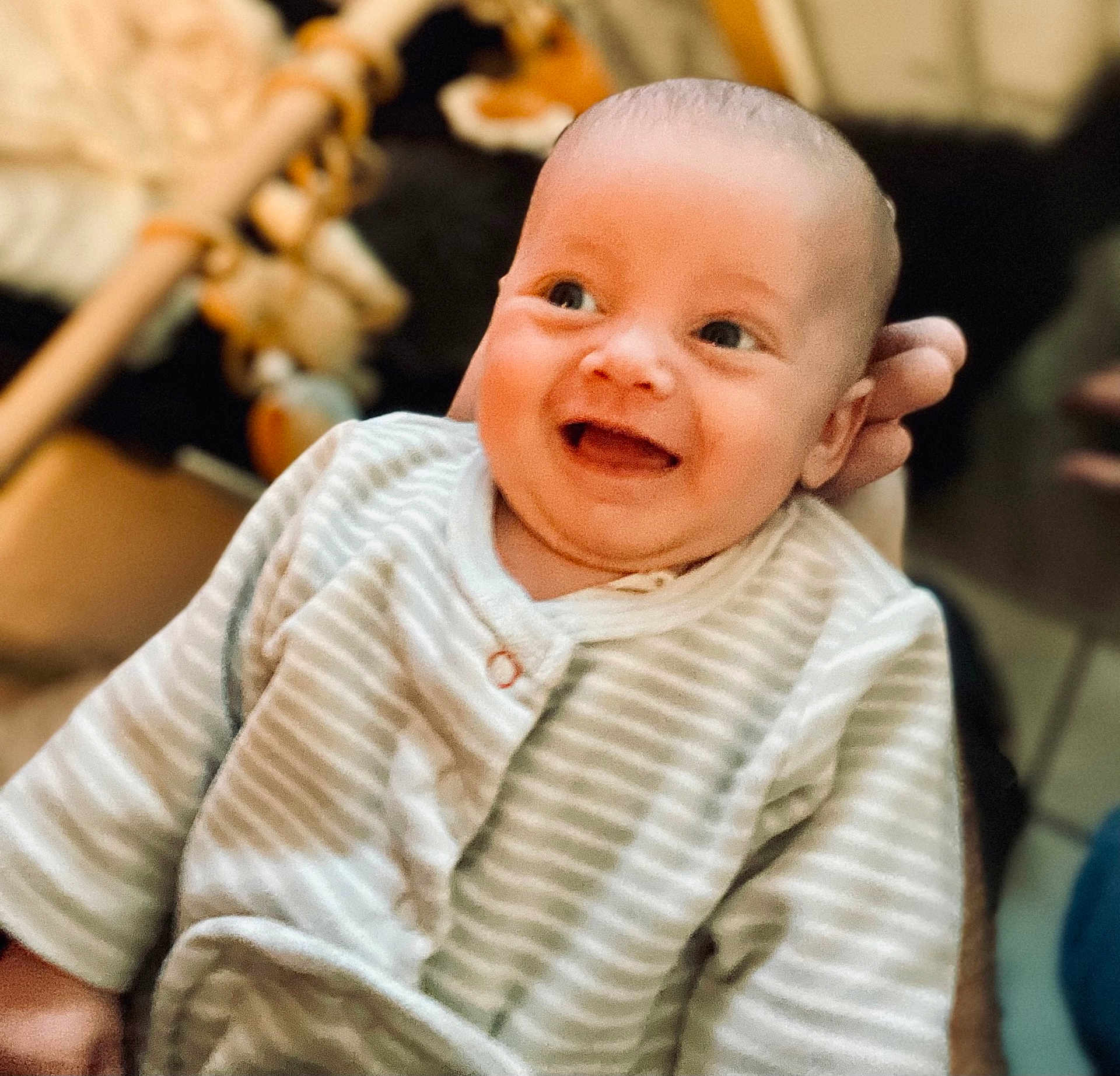 Rafaël participe au concours pour gagner de l'argent avec cette photo : baby, infant, smile, happy, face, person, hand, clothing, striped, onesie, cute, portrait, indoor, soft_lighting, blurred_background, child, newborn, warm_tone, cozy, expression