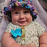 baby, smile, hat, knitted_hat, teething_toy, blue_toy, onesie, patterned_clothing, blanket, soft_texture, cute, happy, infant, child, portrait, indoor, chubby_cheeks, closeup, person, baby_girl