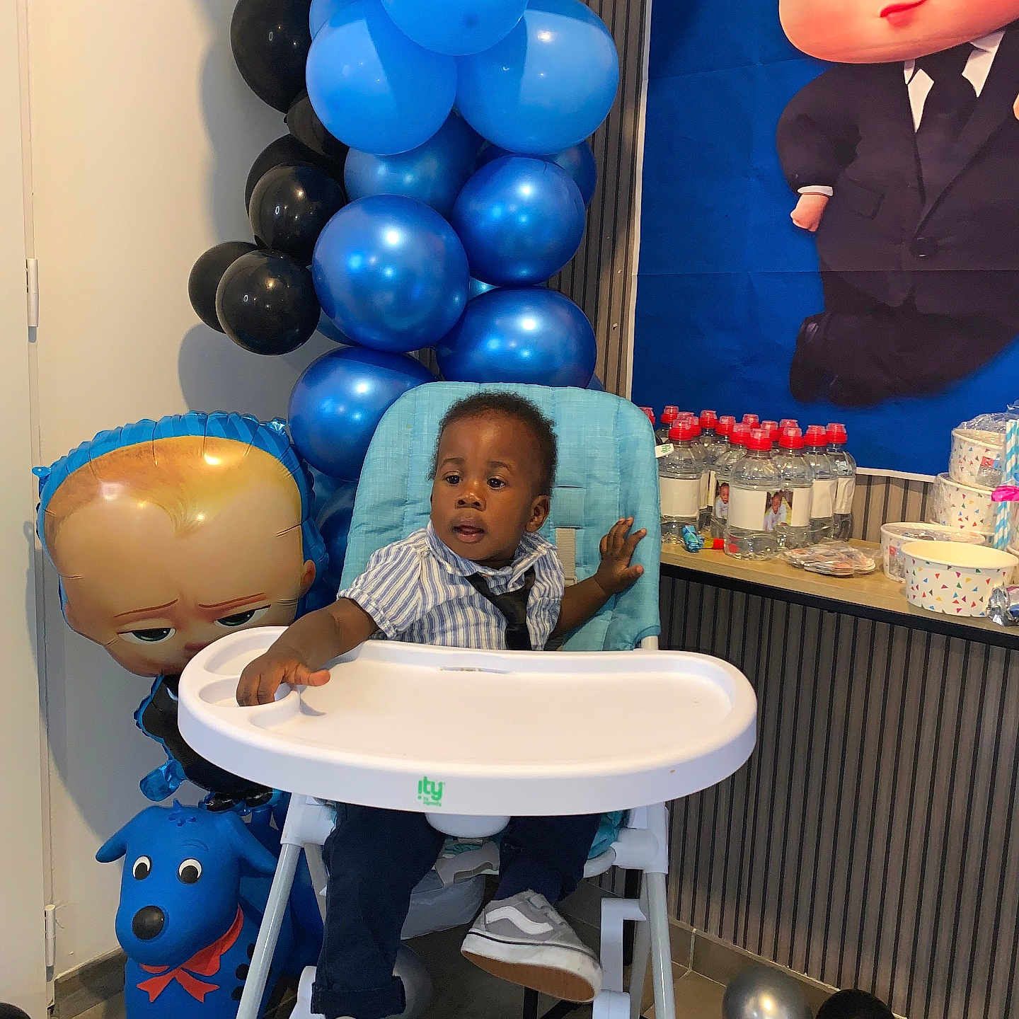Willan a rejoint le concours — aidez-le/la à gagner de superbes lots ! balloons, black, blue, bottle, cartoon, celebration, child, curious, decoration, floor, high_chair, indoor, party, plastic, shirt, shoes, table, tie, toddler, toy
