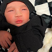 Latrell joined the competition — help win amazing prizes! baby, black_hoodie, blanket, checkered_pattern, child, clothing, cozy, cute, face, hand, hood, indoors, infant, newborn, portrait, resting, sleepy, soft_texture, toddler, young