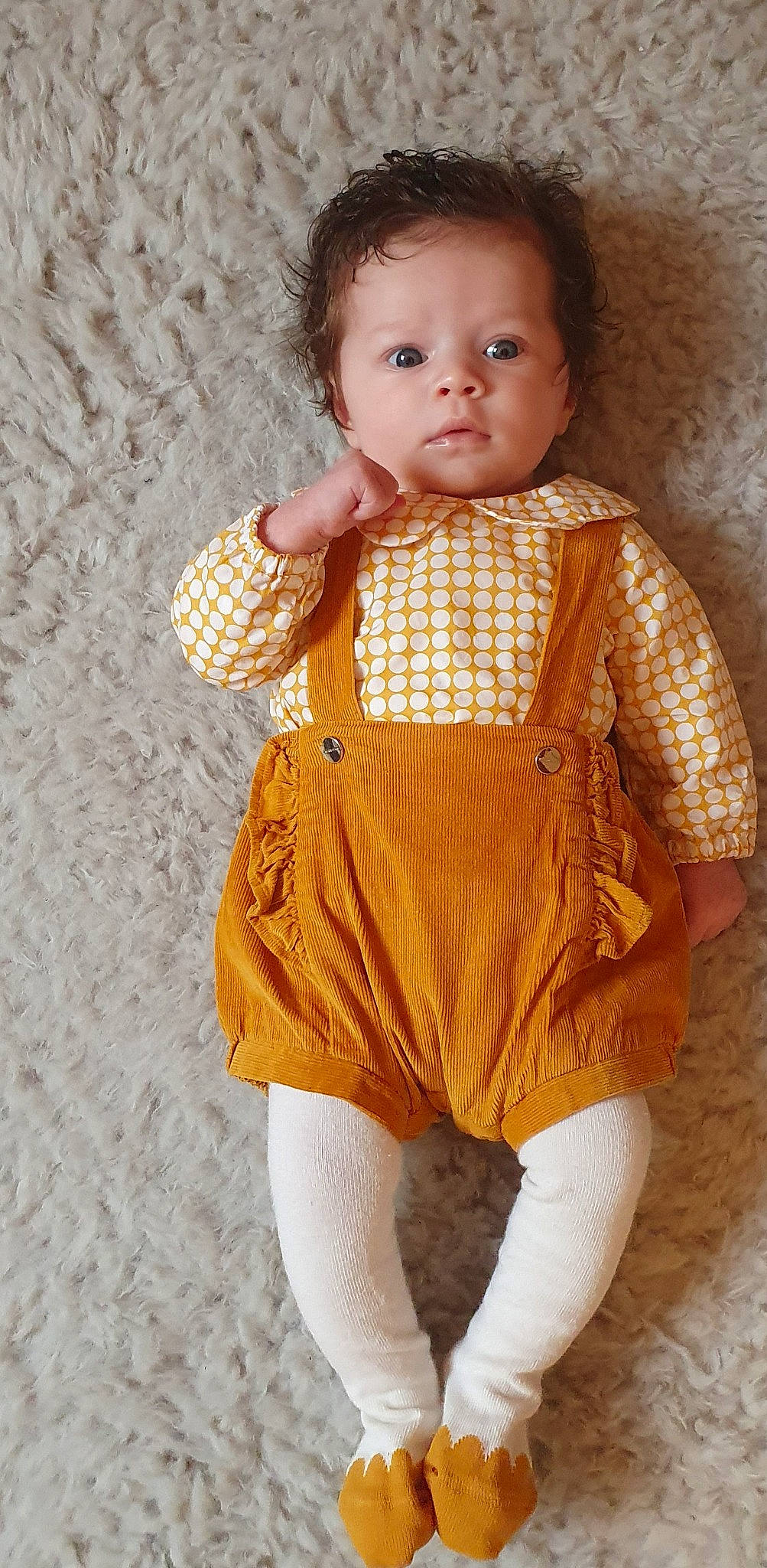 Romy participe au concours pour gagner de l'argent avec cette photo : baby, baby_toddler_clothing, child, dress, eye, face, fashion_design, hairstyle, head, neck, one_piece_garment, orange, pattern, peach, person, skin, sleeve, toddler, toy, wood