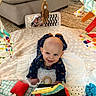 baby, infant, smiling, play_mat, toy, onesie, footprint, couch, carpet, fabric, colorful, soft_toy, mirror, wooden_toy, floor, indoor, child, happy, cute, person