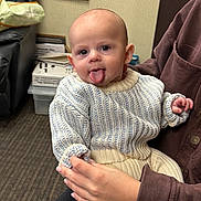 Chase joined the competition — help win amazing prizes! baby, child, person, sweater, knitwear, tongue_out, indoor, hand, holding, couch, calendar, carpet, adult, clothing, cute, expression, face, portrait, seated, cozy