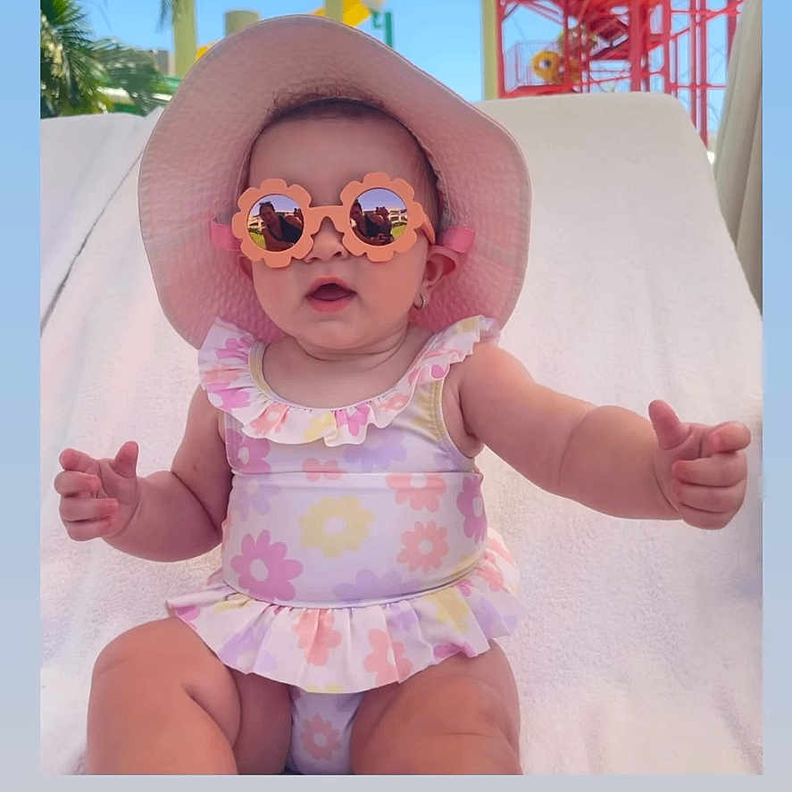 Alora joined the competition — help win amazing prizes! baby, child, sunglasses, hat, swimsuit, poolside, water_park, slide, outdoor, sunny, summer, pink, flower_pattern, toddler, lounge_chair, cute, portrait, smiling, vacation, fun