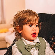 Eden a rejoint le concours — aidez-le/la à gagner de superbes lots ! bow_tie, casual, child, clothing, curly_hair, cute, cute_outfit, expression, face, fashion, hands, home, indoor, person, portrait, seated, toddler, vest, young, young_child